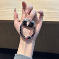Black and warm brown double-strand beaded Apple Watch band with red accent