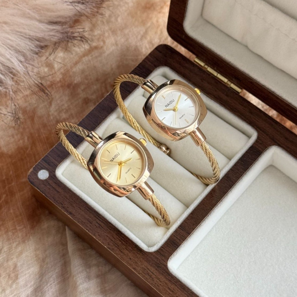 NAIDU braided cable bangle watches in gold tone with champagne and white dials