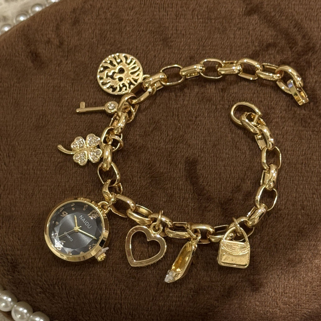 NAIDU charm bracelet watch in gold tone with black dial isolated view