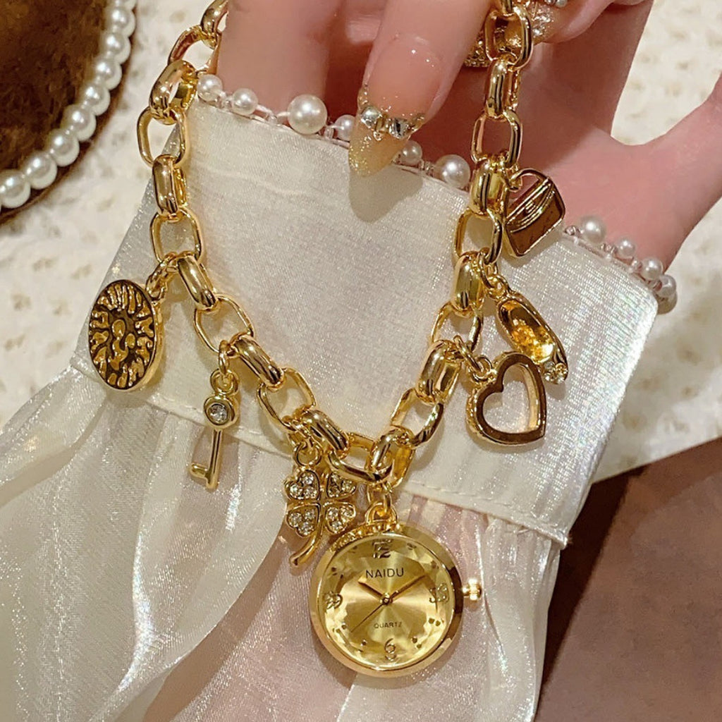NAIDU charm bracelet watch in gold tone with champagne dial hand view