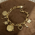 NAIDU charm bracelet watch in gold tone with champagne dial