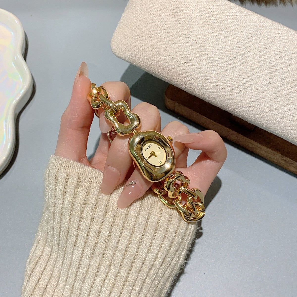 NAIDU sculpted-link jewelry watch in gold tone with champagne dial