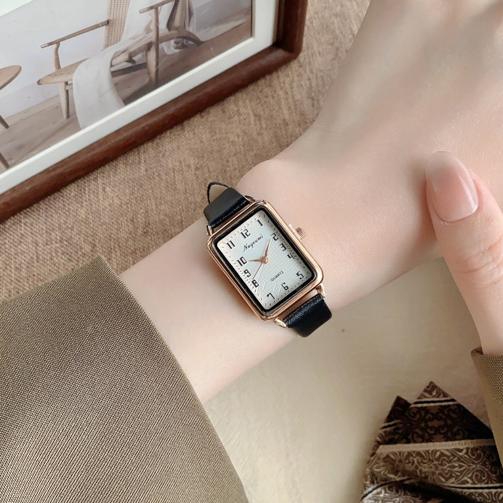 Vintage rectangle women's watch with black strap worn on wrist