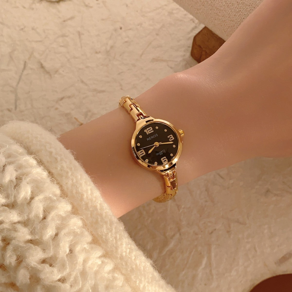 RENOS petite round gold-tone jewelry bracelet quartz watch with black dial