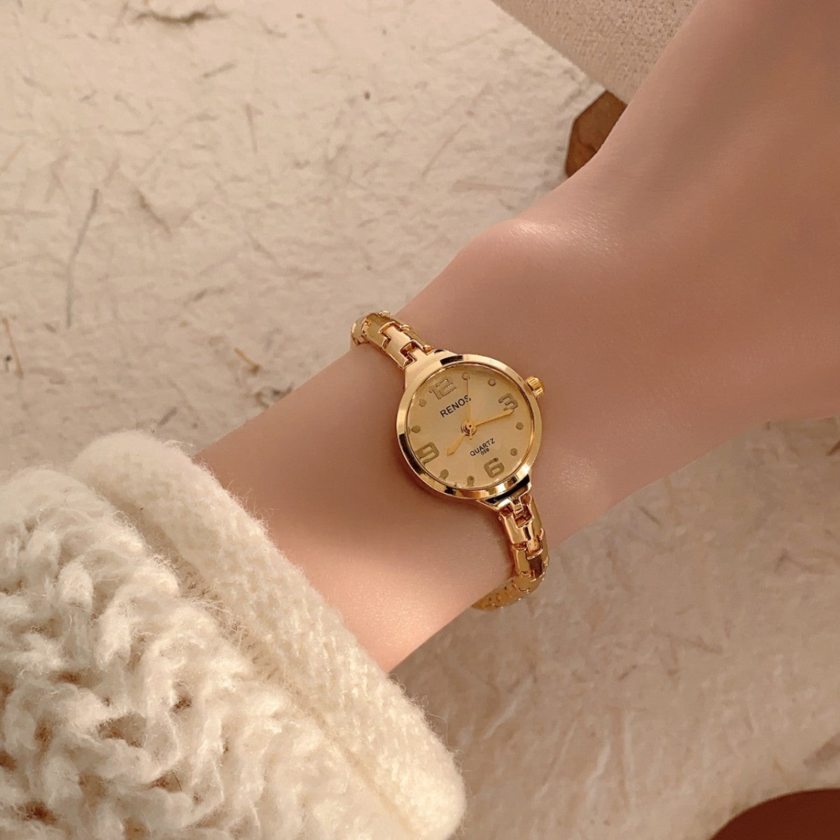 RENOS petite round gold-tone jewelry bracelet quartz watch with light dial