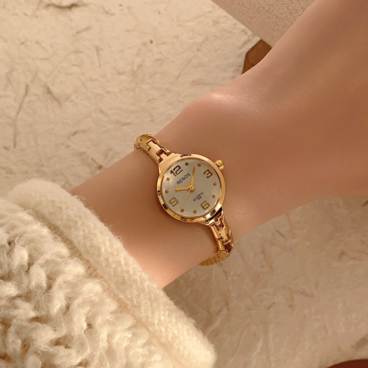 RENOS petite round gold-tone jewelry bracelet quartz watch with white dial