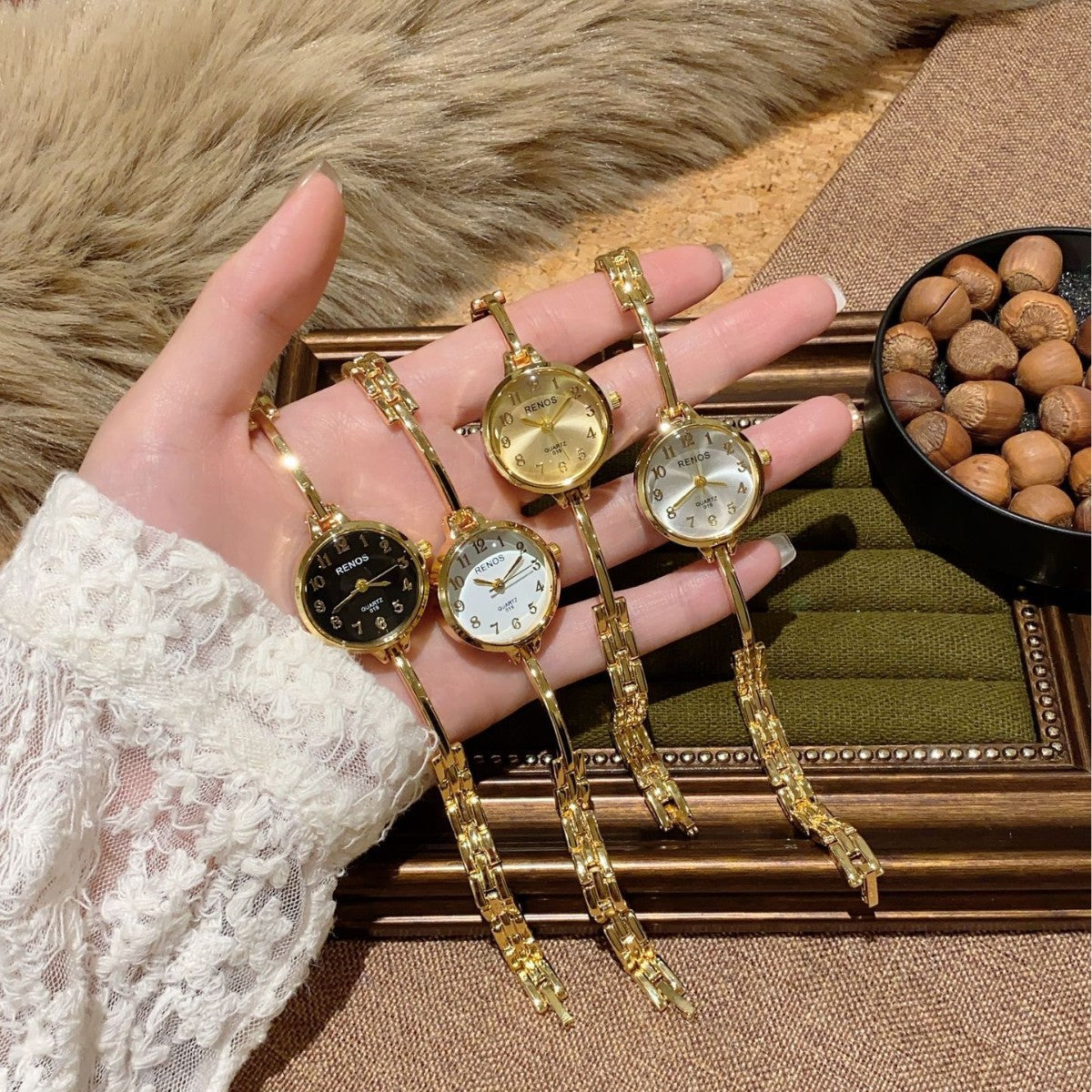 RENOS petite round bar-link bracelet quartz watch collection in gold tone with black white champagne and silver dials