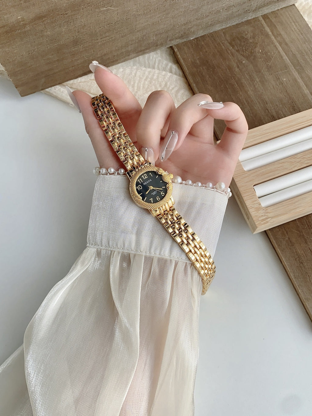 RENOS textured bezel bracelet watch in gold tone with black dial