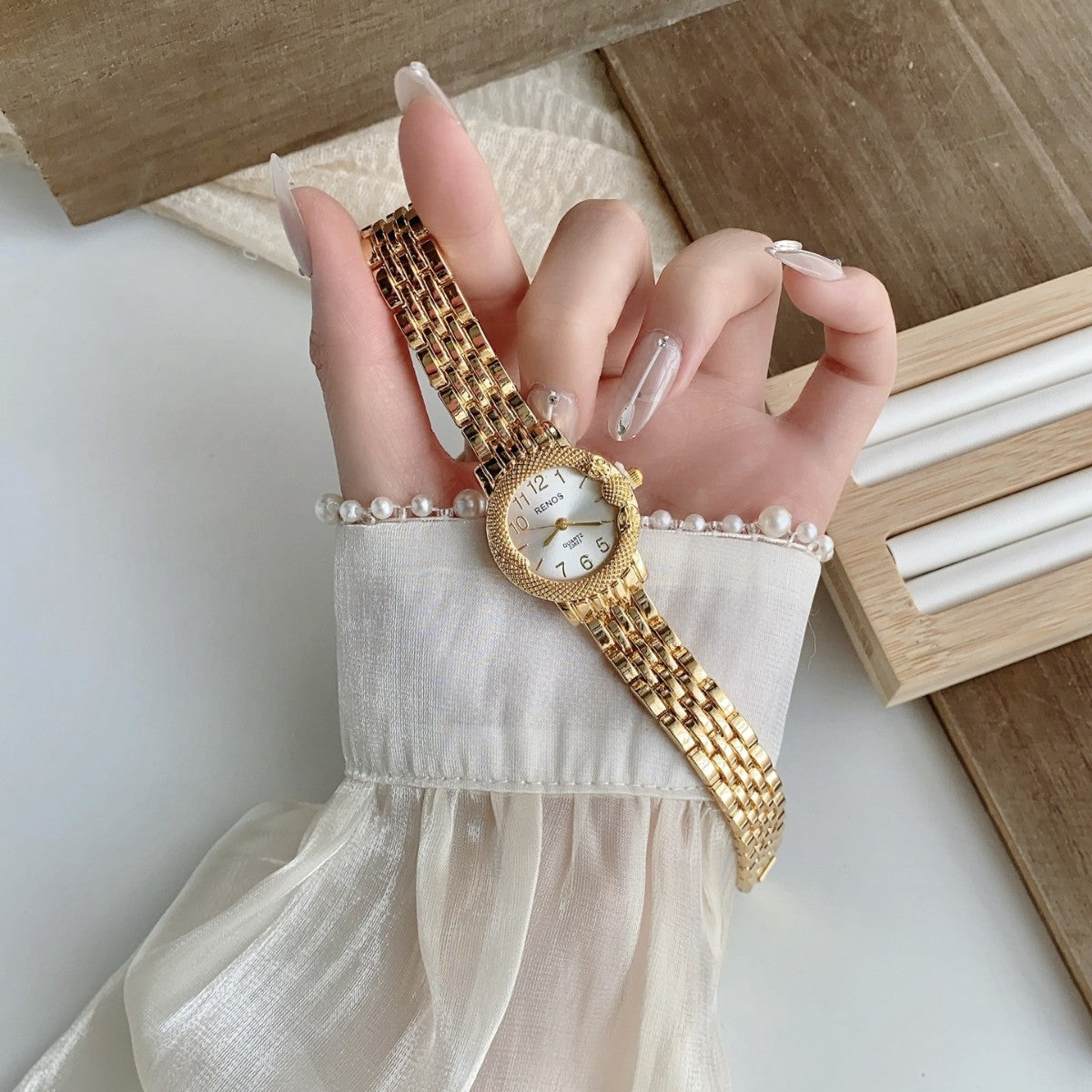 RENOS textured bezel bracelet watch in gold tone with white dial