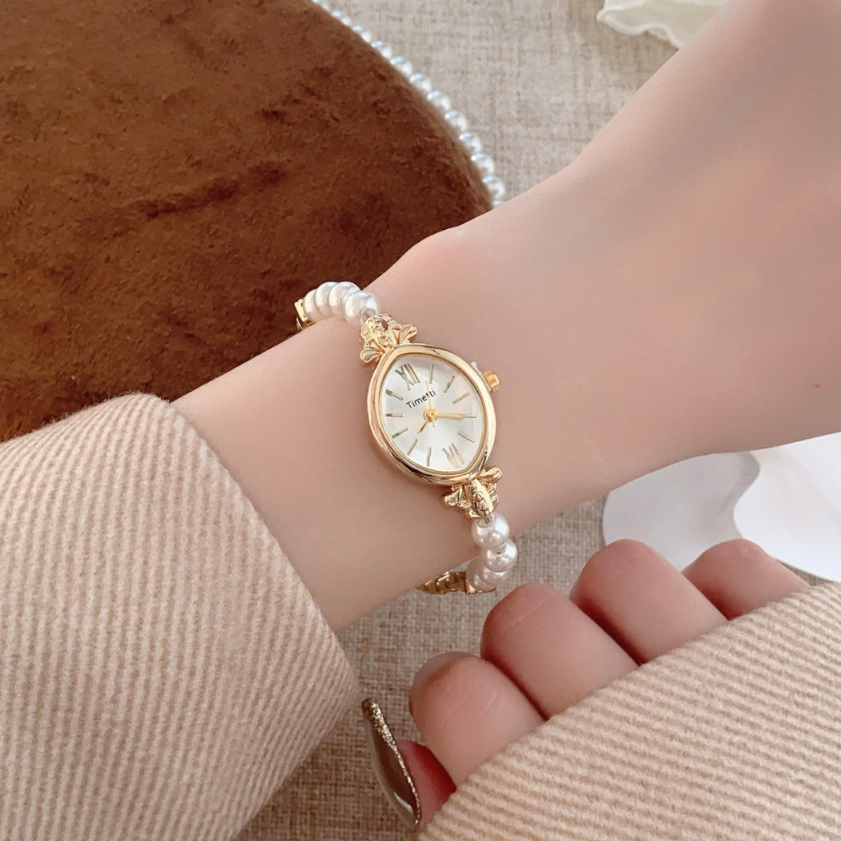 Timett single-pearl bracelet watch in gold tone worn on wrist
