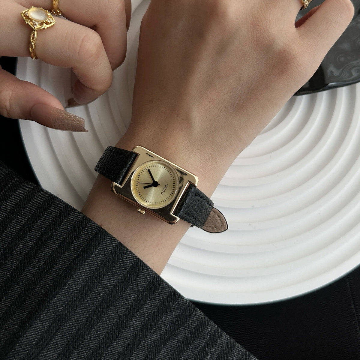 Vintage academy square women's watch with gold case, black leather strap and champagne dial on wrist