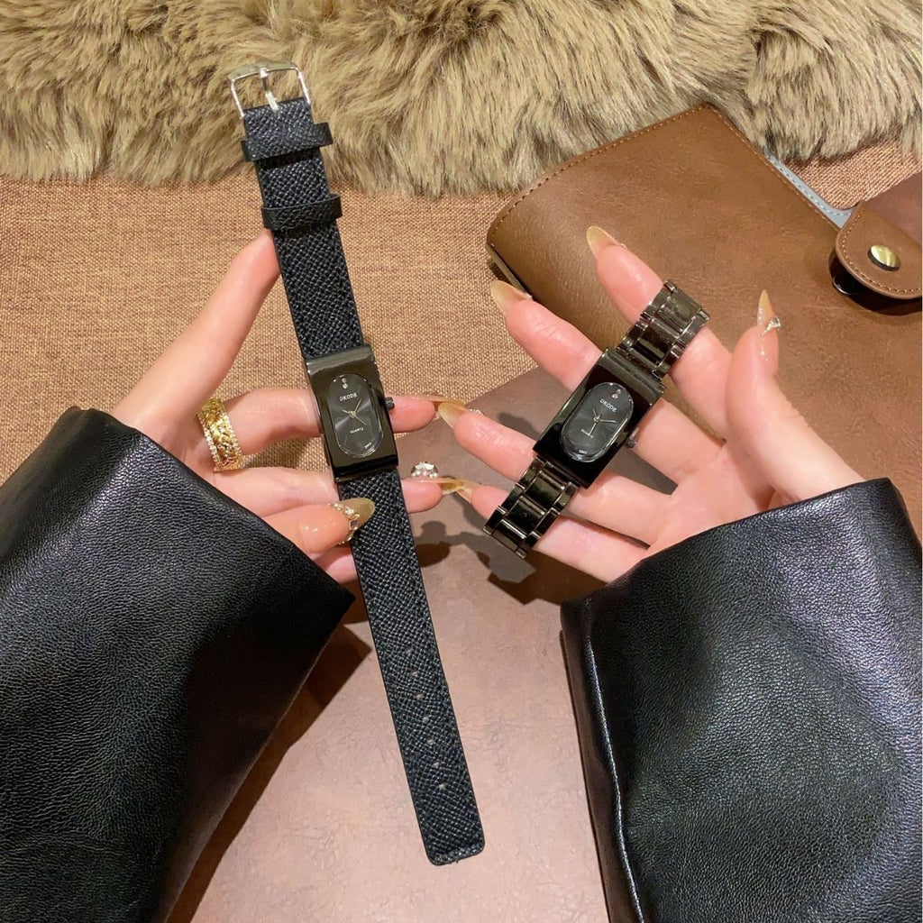 Vintage petite black tonneau women's quartz watch shown with leather-style strap and black metal bracelet