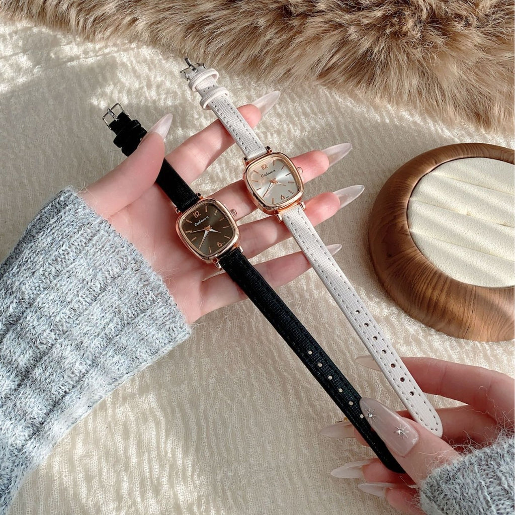 Vintage cushion case women's watches with black and ivory leather straps in a lifestyle pair