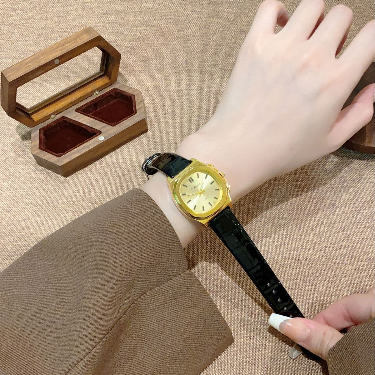 Vintage gold-tone cushion women's watch with black croc-embossed leather-style strap on wrist
