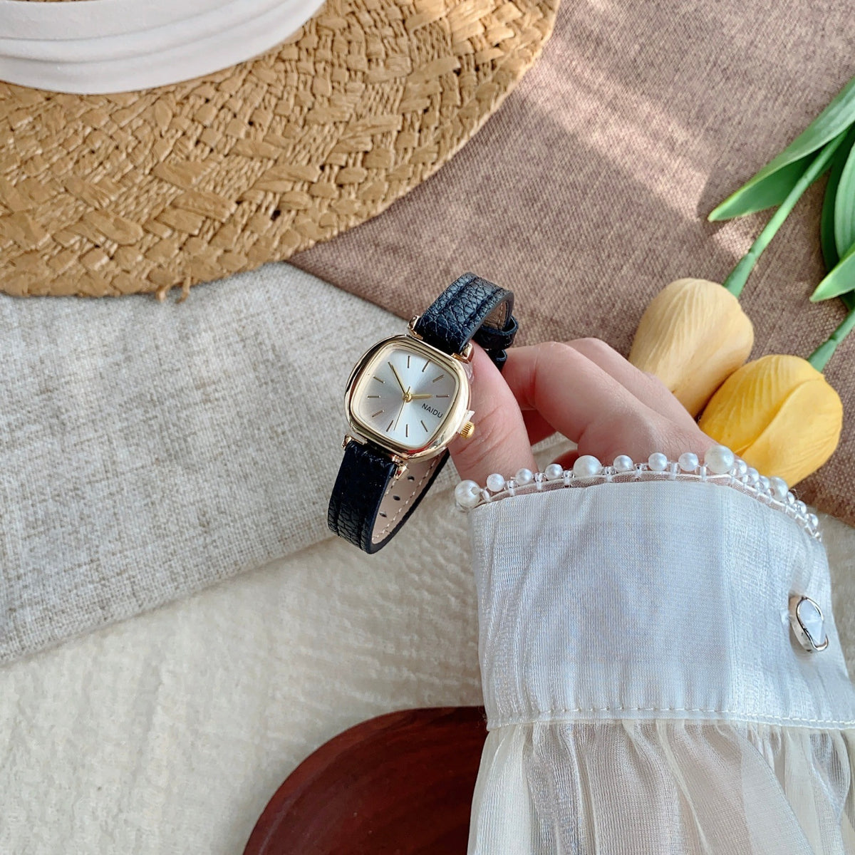 Black strap petite rounded-square women's watch in a folded product view