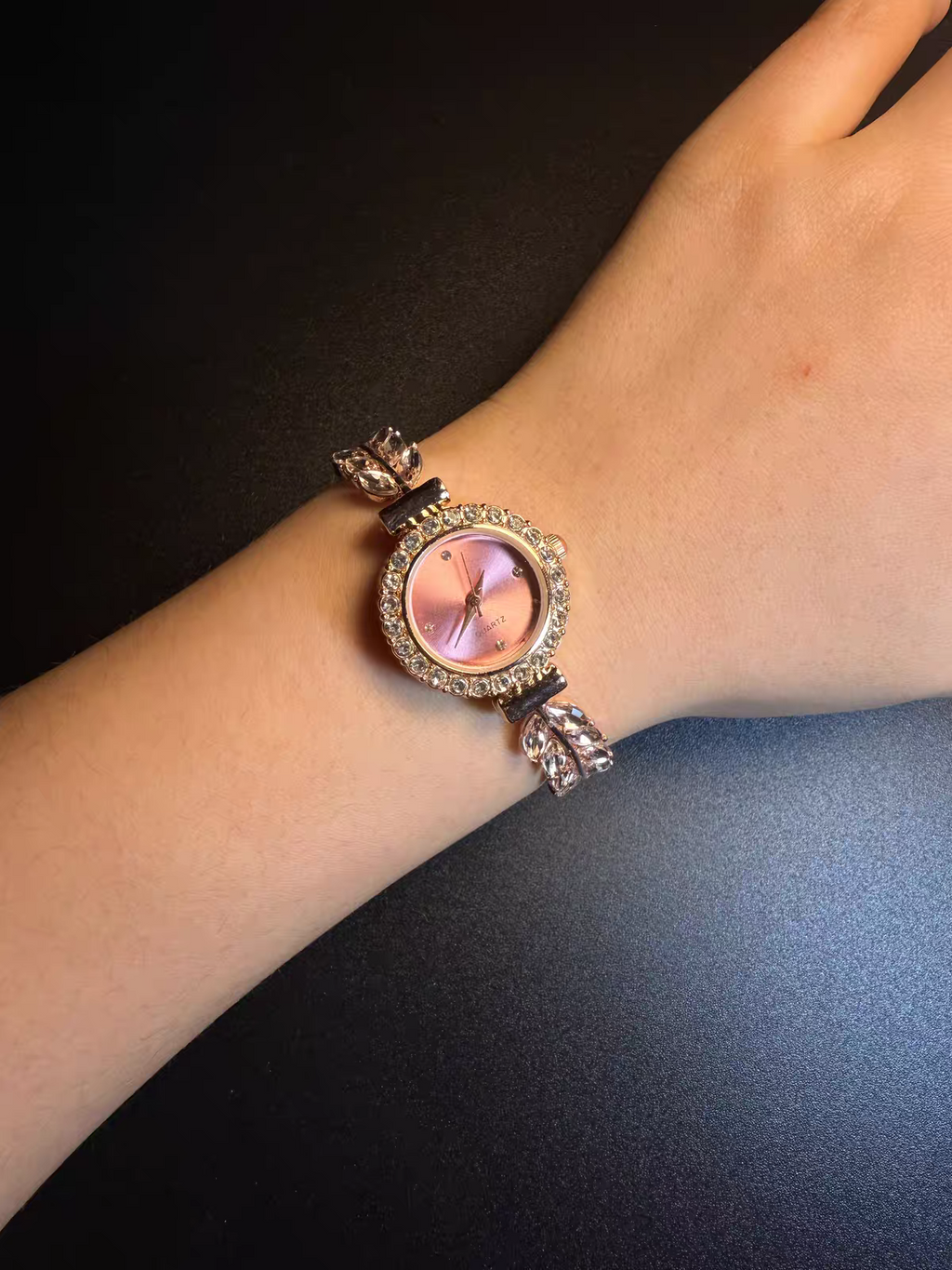 Pink dial crystal leaf bracelet watch worn on wrist