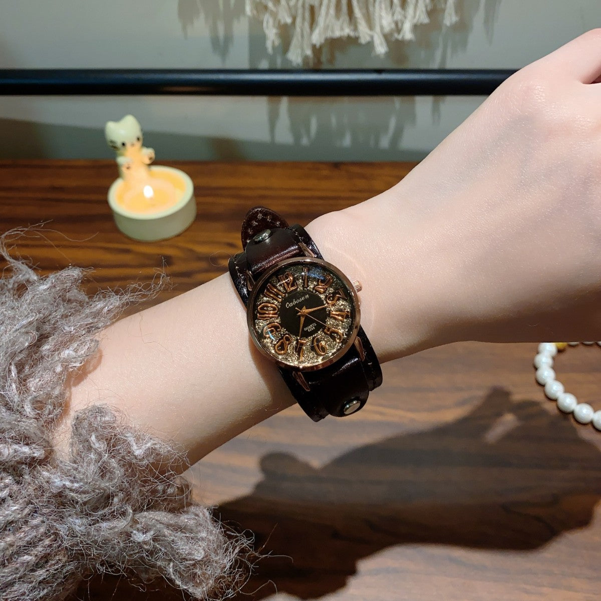 Vintage rivet leather strap unisex watch with black strap and black Arabic numeral dial on wrist